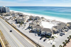 A coastal hotel with multiple-story buildings, a parking lot, and a beach view. - Beautiful Dog Friendly Canal Front 4205 1BR with Free Beach Service for 2! (Destin)