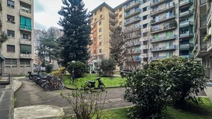 A residential area with apartment buildings, a large tree, and parked bicycles. - Boutique Apartment 60sqm between Sempione & CityLife with Studio Space (Milano)