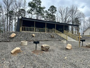 A building with a staircase leading to a covered area, surrounded by gravel and rocks. - Texas Cabin

Wonderful 3-bedroom triplex in charming Kirby next to the lake. (Kirby)