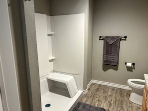 A bathroom with a shower, toilet, and a towel rack. - Texas Cabin

Wonderful 3-bedroom triplex in charming Kirby next to the lake. (Kirby)
