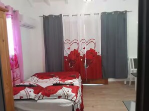 A bedroom with a bed, a desk, and a chair. - Gîtes Les Colibris Jaunes_Appart. No1_Citronnelle with swimming pool in Marie-Galante (Grand-Bourg de Marie-Galante)