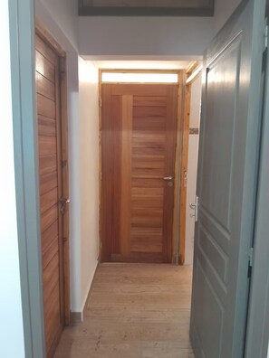 A hallway with wooden doors and a light fixture above the door. - Gîtes Les Colibris Jaunes_Appart. No1_Citronnelle with swimming pool in Marie-Galante (Grand-Bourg de Marie-Galante)