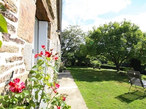 A stone building with a pathway leading to a grassy area with a bench. - Rustic house with garden - 4 guests (Sourdeval)