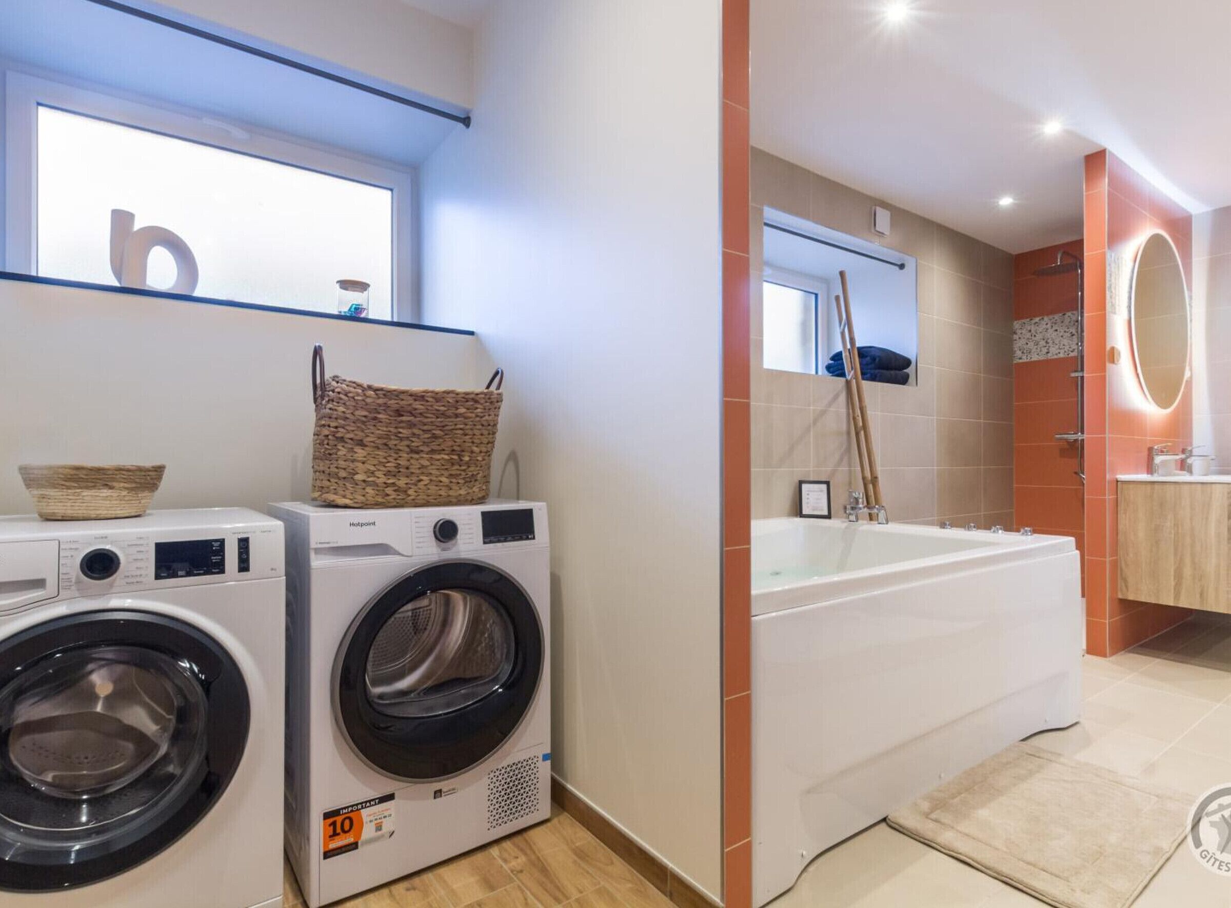 A laundry area with two front-loading washing machines and a basket on top.