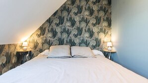 A bedroom with a bed, two bedside lamps, and a patterned wallpaper. - Comfortable house, pets allowed - 8 guests (Saint-Germain-sur-Ay)