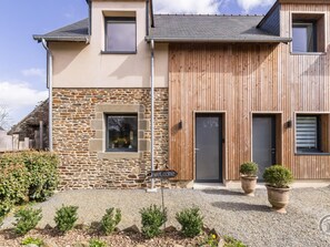 A modern house with a stone facade, wooden paneling, and a welcome sign. - Charming house, pets welcome, parking - 4 guests (Saint-Aubin-de-Terregatte)