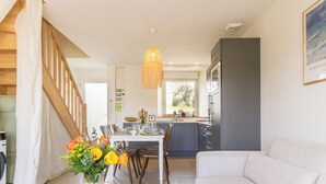 Eine moderne Küche mit Essbereich, einer Treppe und einem Wohnzimmer mit Sofa.