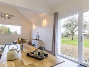 A modern dining area with a wooden table, a kettle, and a tray with cups. - House with parking, nature retreat - 4 guests (Céaux)