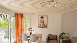 Un salon moderne comprenant un coin repas, un canapé, une table basse et un tableau accroché au mur.