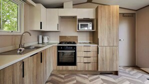 A compact kitchen with a built-in microwave, a gas stove, and a small oven.