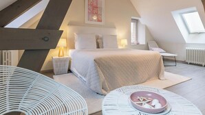 A bedroom with a bed, bedside tables, a chair, a window, and a radiator. - Detached house with panoramic view - 8 guests (Portbail)