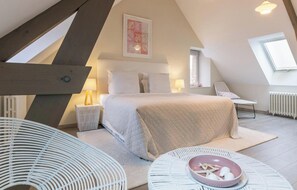 A bedroom with a bed, bedside tables, a chair, a window, and a radiator. - Detached house with panoramic view - 8 guests (Portbail)
