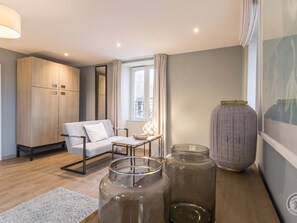 A modern living room with a sofa, a table, a large vase, and a wardrobe. - Detached house with panoramic view - 8 guests (Portbail)