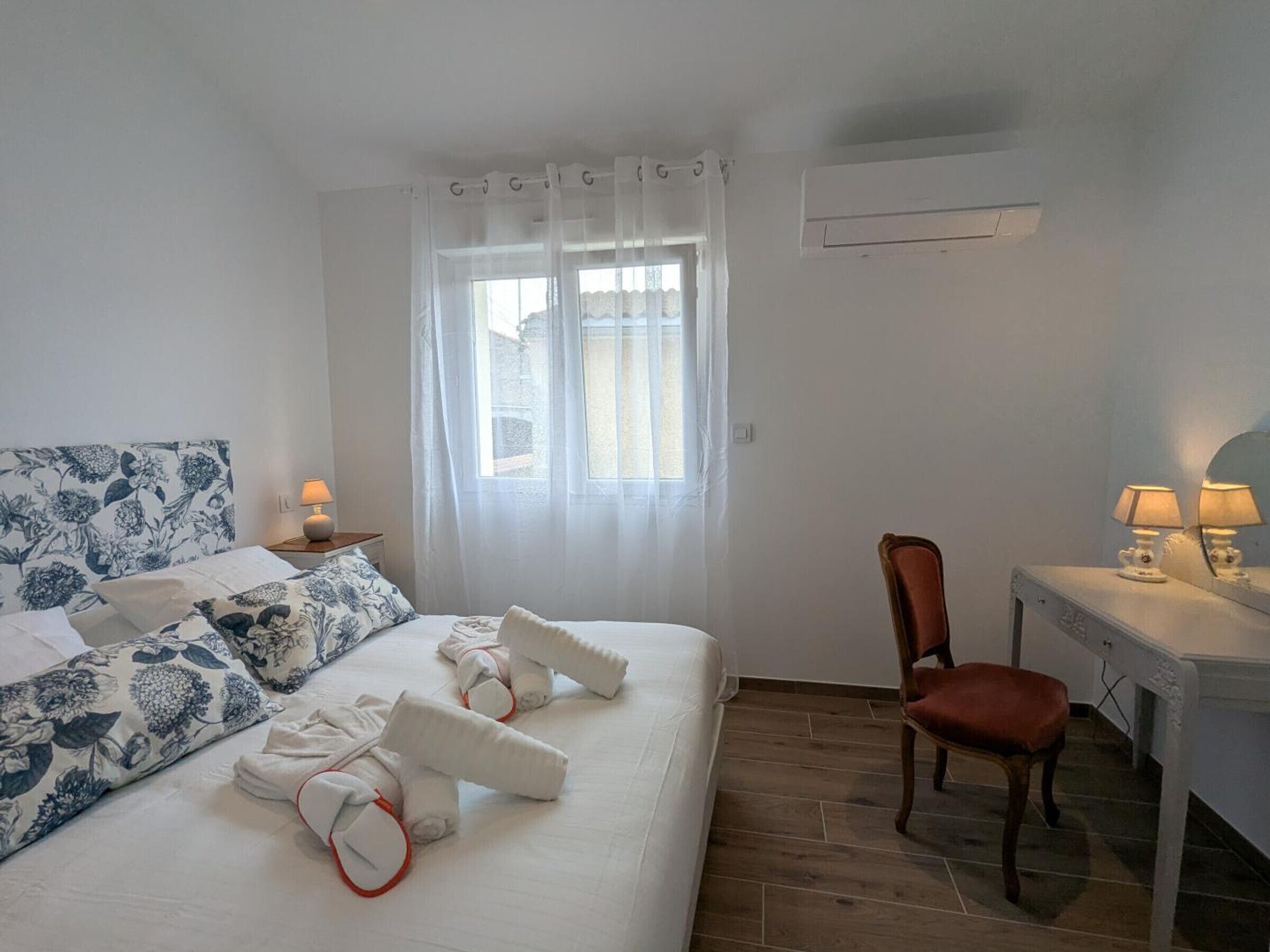 Ein Hotelzimmer mit Bett, Sessel, Schreibtisch und Klimaanlage.