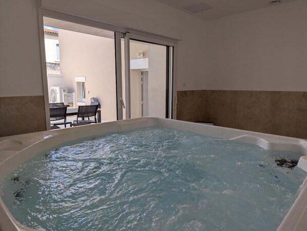Un bain à remous avec vue sur un espace patio extérieur.