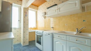 A compact kitchen with a stove, oven, sink, and white cabinets. - Apartment between ocean and forest - 6 guests (Mimizan)