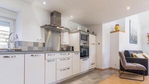 Eine moderne Küche mit Einbauofen, Mikrowelle und Edelstahl-Dunstabzugshaube.
