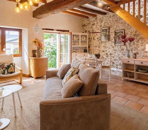 Un salon confortable avec un canapé, une table à manger et un escalier.