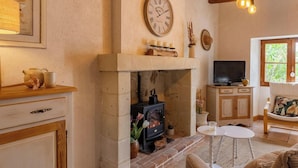 Un salón acogedor con chimenea, televisor y zona de estar confortable.