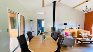 A spacious living area with a dining table, chairs, a sofa, and a fireplace.