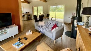 A spacious living area with a sofa, coffee table, TV, and a fireplace.