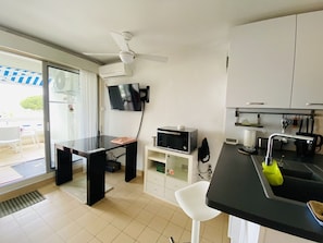 Een moderne keuken met een flatscreen televisie, een magnetron en een spoelbak.