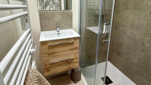 A modern bathroom with a glass shower enclosure, a white sink, and a wooden vanity. - Spacious house, beach 400m away - 12 guests (Carnac)