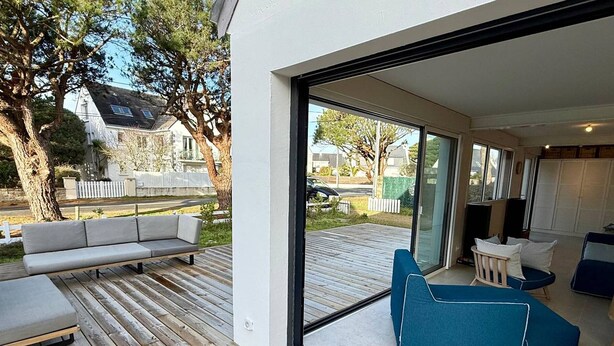 A modern outdoor living space with a wooden deck, a sofa, and a blue chair. - Spacious house, beach 400m away - 12 guests (Carnac)