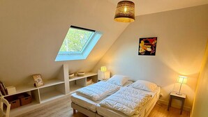 A bedroom with a skylight, a bed, bedside tables, and a shelf unit. - Spacious house, beach 400m away - 12 guests (Carnac)
