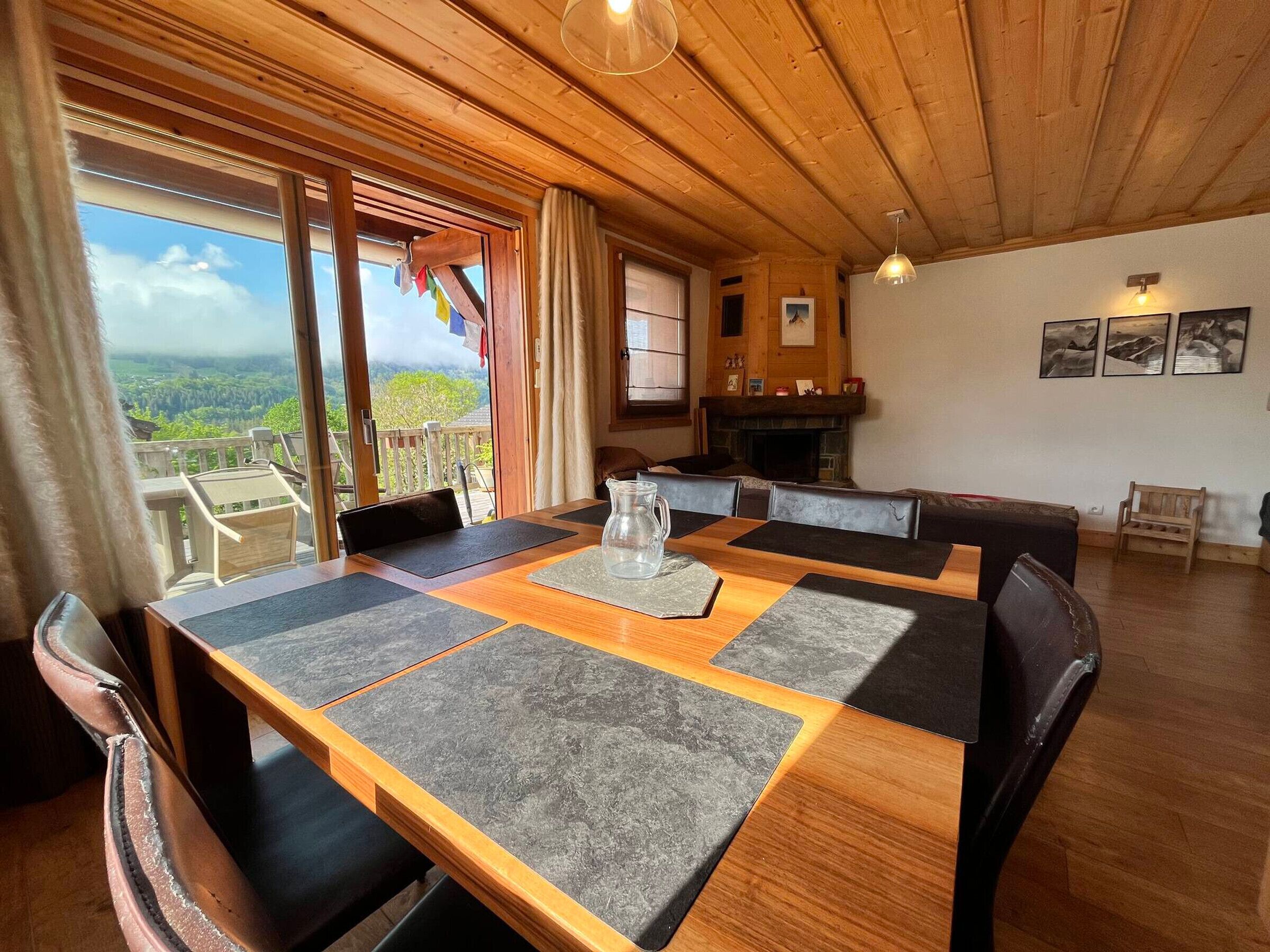 Un espace repas avec une table en bois, des chaises et une vue sur l’extérieur.