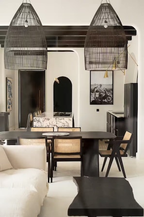 A modern dining area with a marble table, wicker chairs, and black pendant lights. - Luxurious 3 BR villa, 100 meters from the Beach (Seseh)