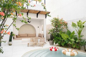Ein Poolbereich mit Liegestühlen, einer Sitzecke und einem kleinen Pool.