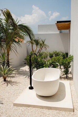 A modern outdoor bathroom with a large white tub, surrounded by small plants and a clear sky. - Gorgeous 2 Br , 100m from beach (Seseh)