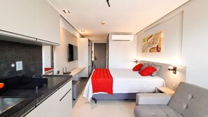 Ein modernes Hotelzimmer mit Bett, Schreibtisch, Fernseher und einem Bild an der Wand.