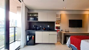 Eine moderne Küche mit Mikrowelle, Spüle und einem Phico-Kühlschrank.