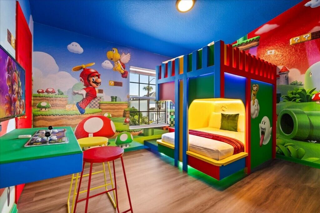 Een vrolijke kinderkamer met een bed, een tafel en een muurschildering van Mario en Luigi.