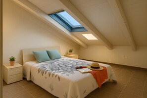 Ein Schlafzimmer mit Dachfenster, einem Bett mit floralem Überwurf, einem Nachttisch mit Pflanze und einem Hut auf dem Bett.