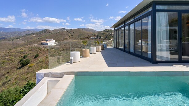 Ein moderner Poolbereich mit freiem Blick auf die umliegende Landschaft.