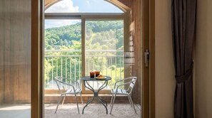 A balcony with two chairs, a table, and a glass of iced tea. - Gapyeong Valley Scoop Pension (Gapyeong)