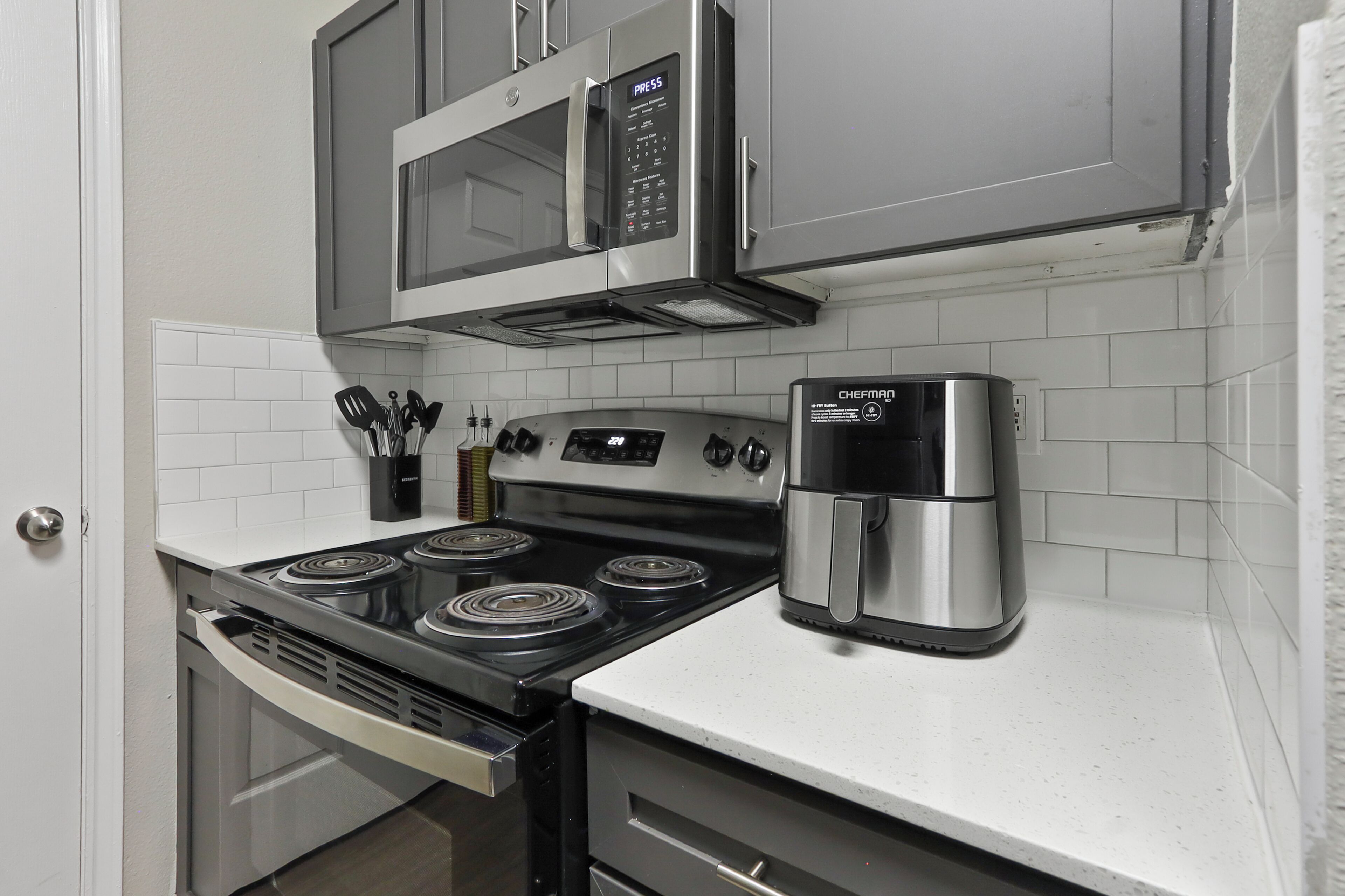 A kitchen with a stainless steel stove, a microwave, and a coffee maker.