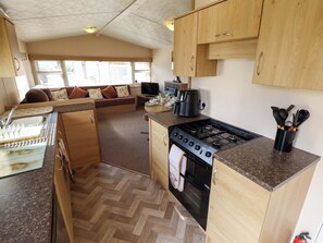 A compact kitchen with a stove, oven, and a coffee maker.