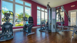 A gym with various exercise equipment, large windows, and a view of the outdoors. - Last Minute Disney Getaway! Townhome with Themed Bedrooms. Book Now! #170005 (Orlando)