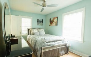 A bedroom with a bed, a ceiling fan, a window, and a door. - Parkside Retreat (Louisville)
