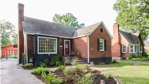 Een herenhuis met twee verdiepingen, een voortuin, een garage en een verzorgde tuin.