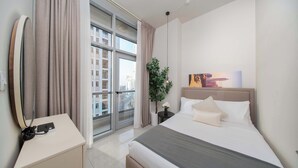 Camera d'albergo con un letto, un comodino e vista sulla città da una grande finestra.
