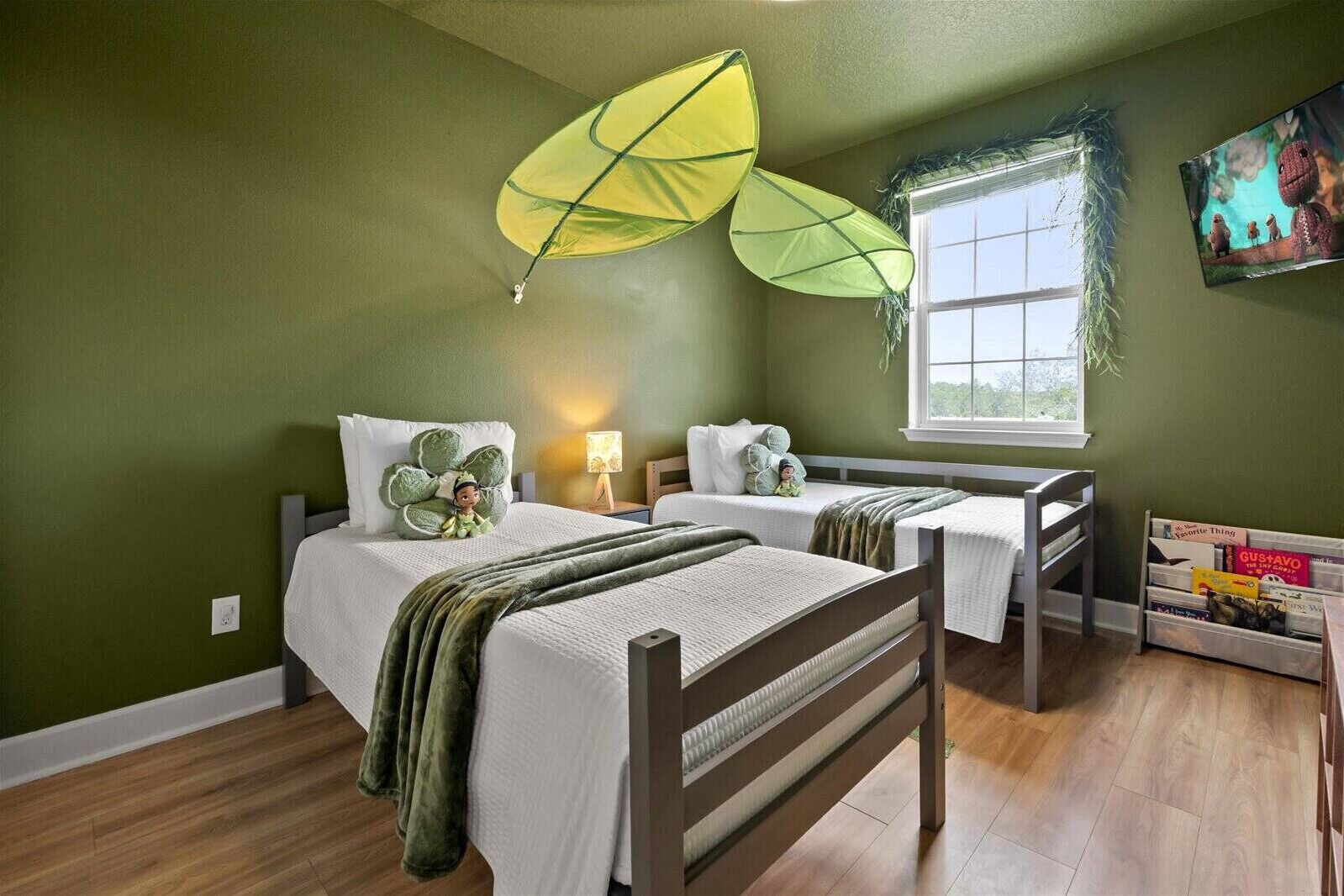 A bedroom with two beds, a window, a TV, and a bookshelf.
