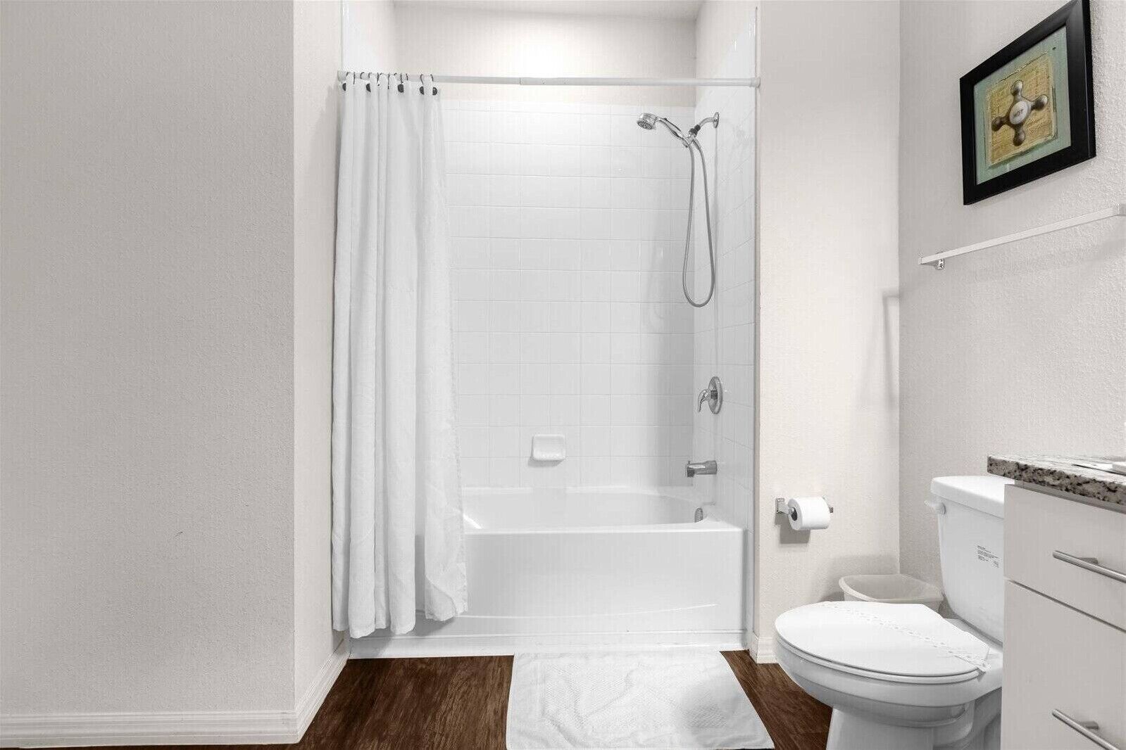 Ein Badezimmer mit Dusche, Toilette und Waschbecken.