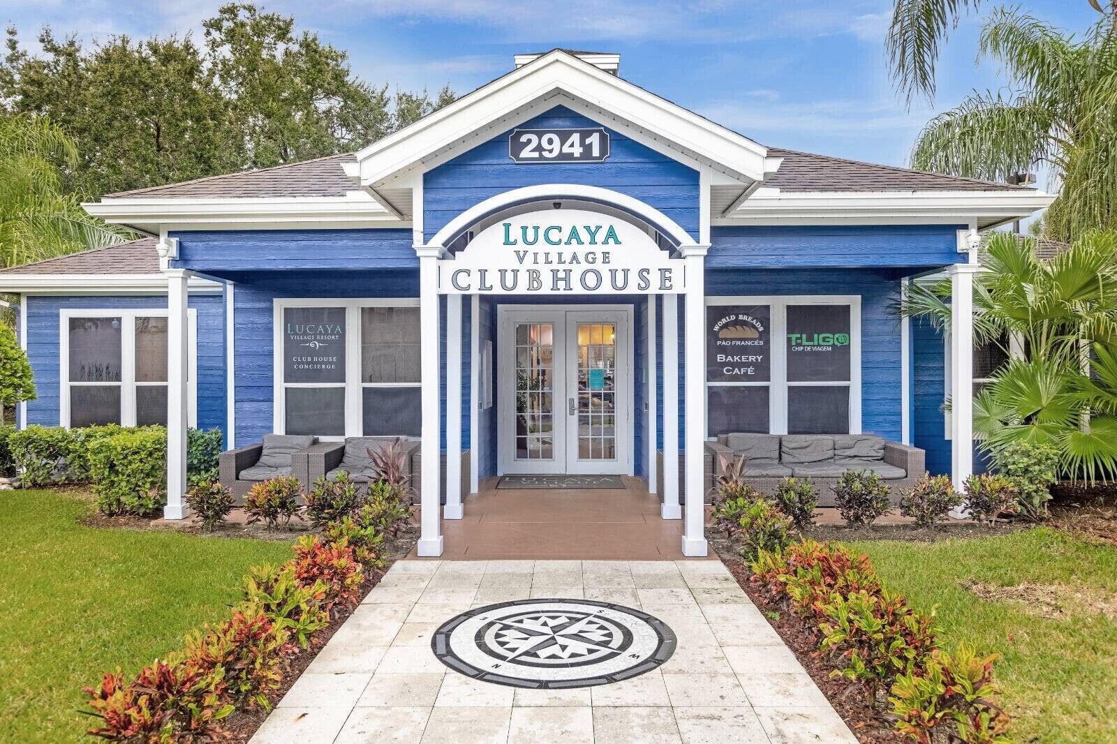 Un edificio azul con un cartel que dice 'Lucaya Village Clubhouse' y el número '2941' sobre la entrada.