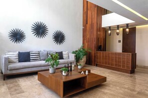 Ein stilvolles Wohnzimmer mit einer Couch, einem Couchtisch und Wanddekoration.