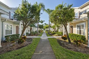 A residential street with houses, a central sidewalk, and trees. - Last Minute Disney Getaway! Modern Townhouse. Book Now! #166743 (Orlando)